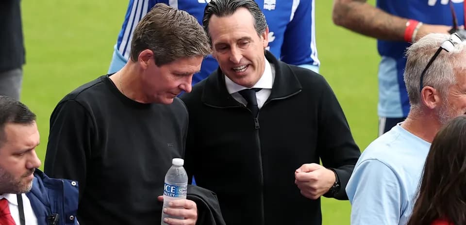 Two men conversing near football pitch