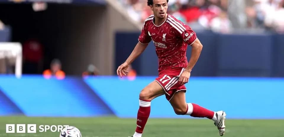 Player in Liverpool kit dribbling the ball during match