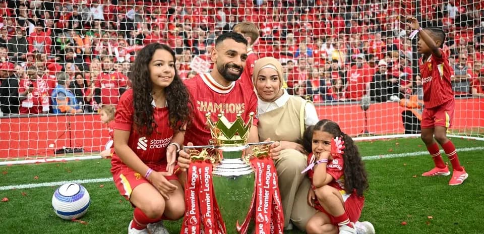 Player celebrating with family and trophy on field