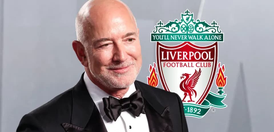 Man in tuxedo with Liverpool FC logo in background