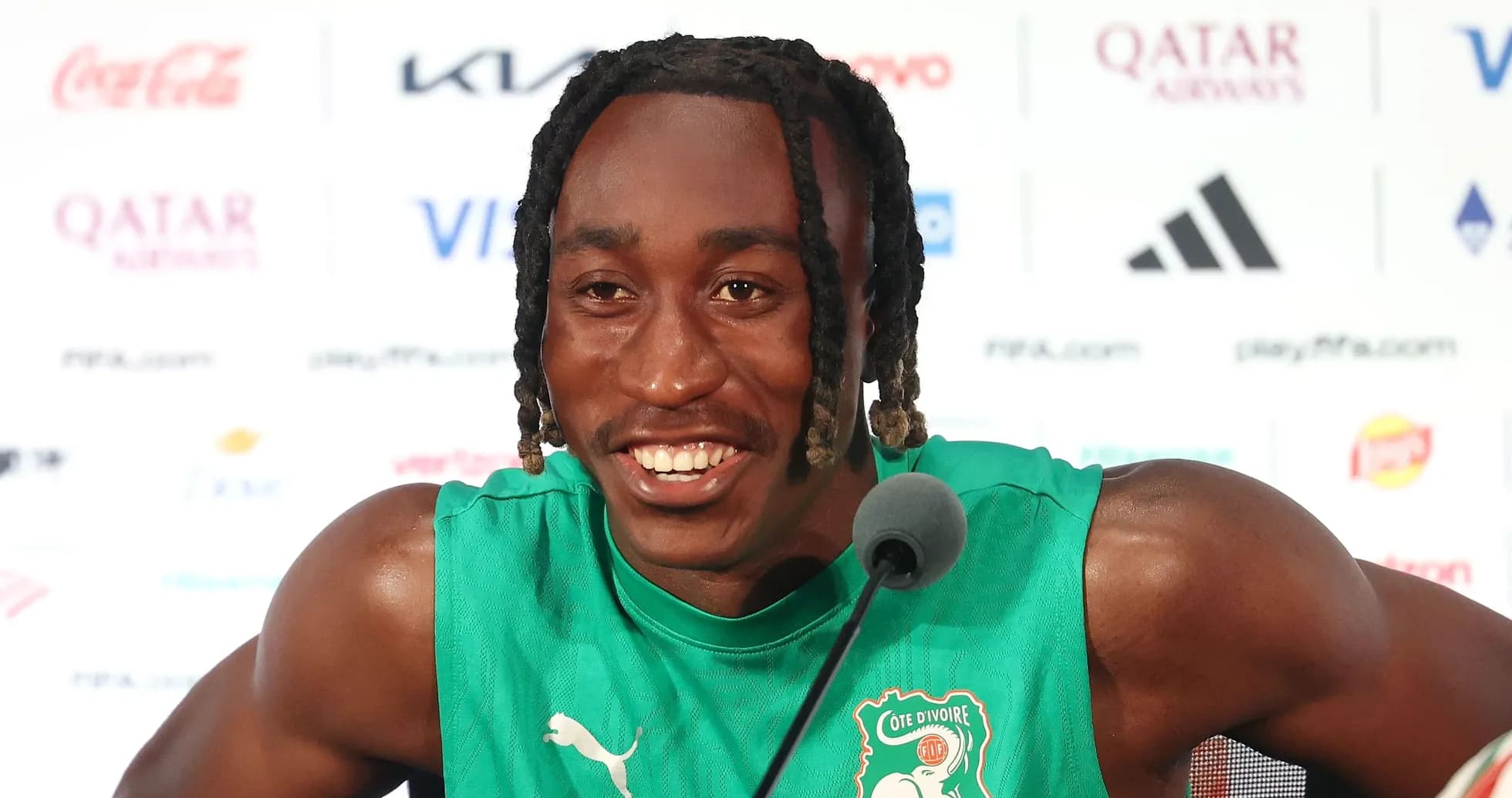 Player speaking at press conference in green jersey