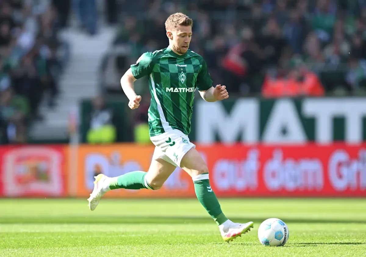 Player in green jersey running with soccer ball