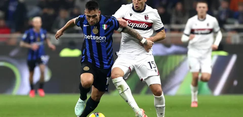 Bologna player challenges Inter player for the ball