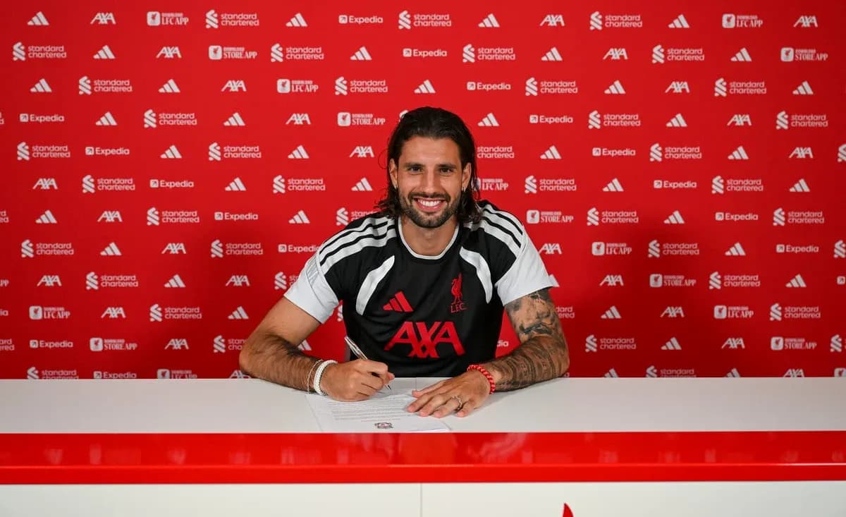 Player signing contract at press conference table