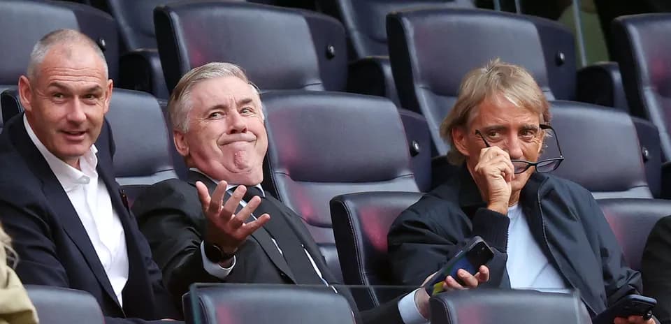 Three men seated in stadium watching event