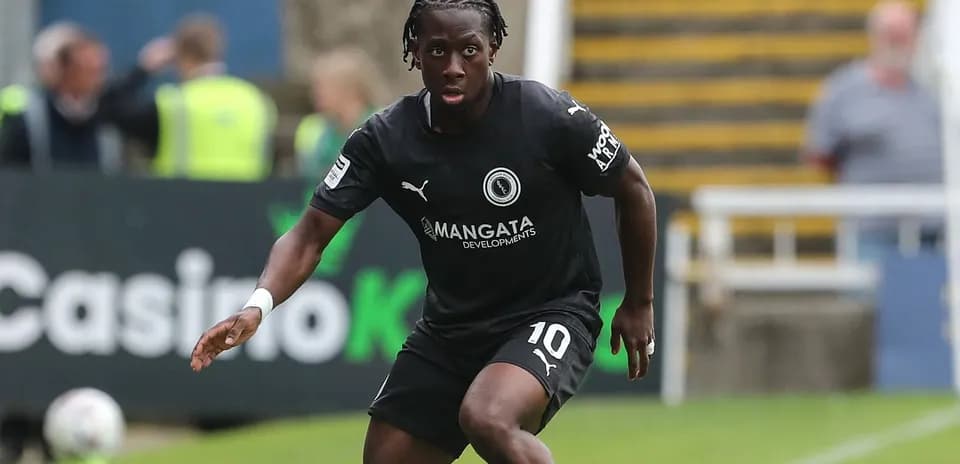 Player in black kit running with the ball