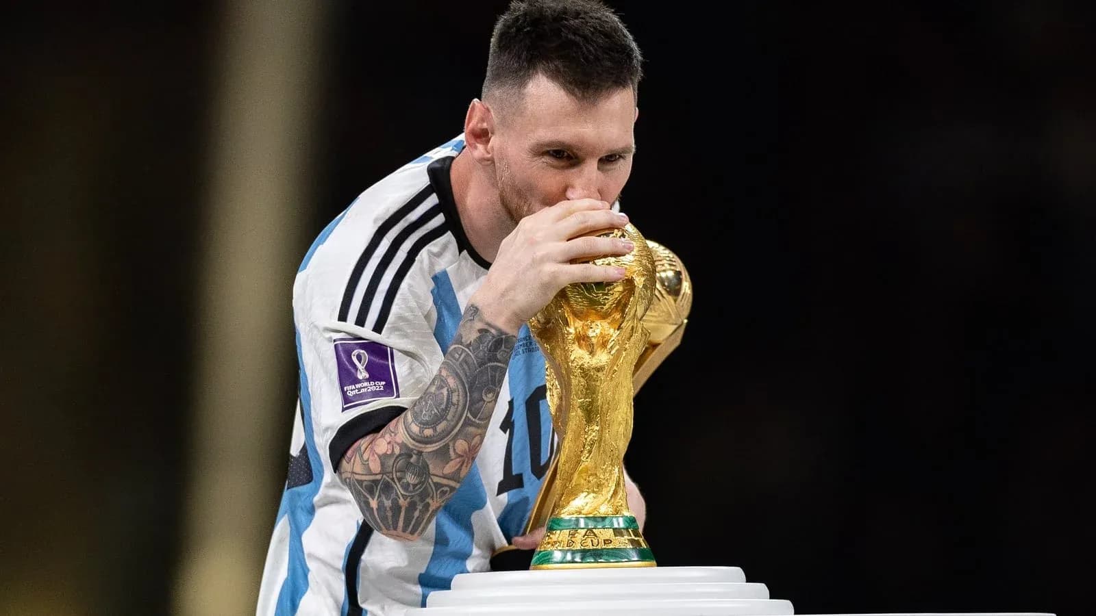 Player holding and kissing FIFA World Cup trophy