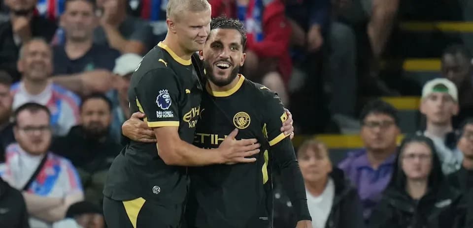 Two Manchester City players celebrating a goal together