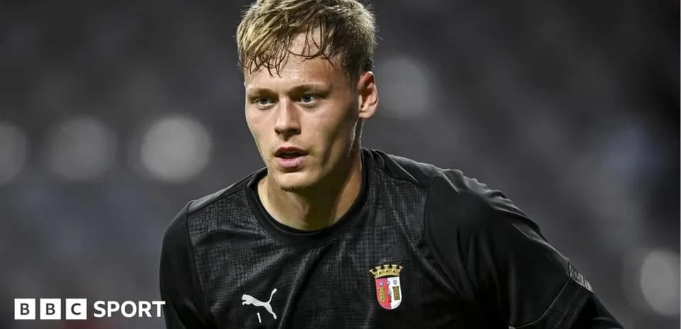 Goalkeeper in black uniform during match warm-up