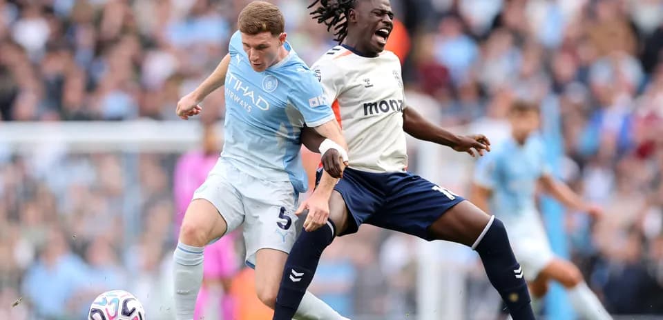 Manchester City player tackling Coventry opponent