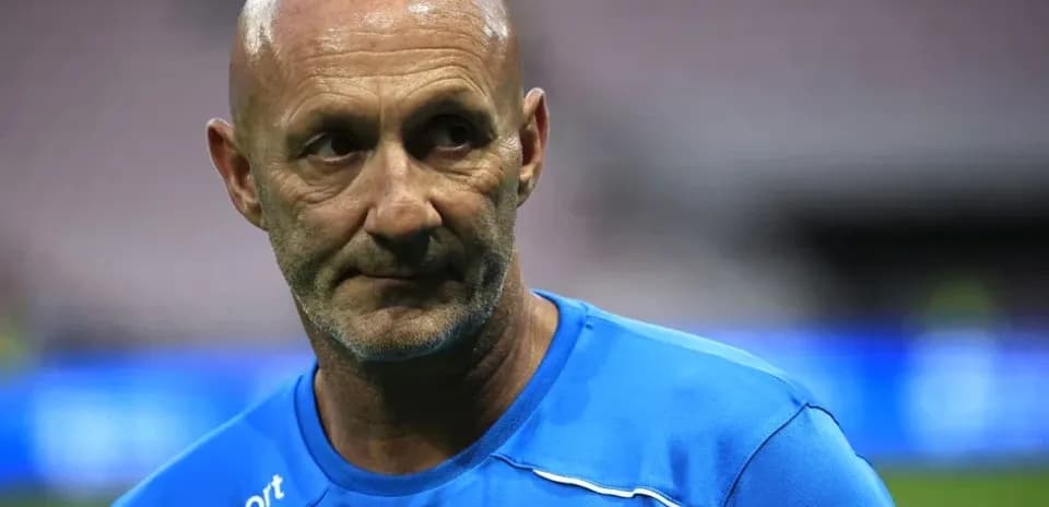 Coach in blue training shirt on field