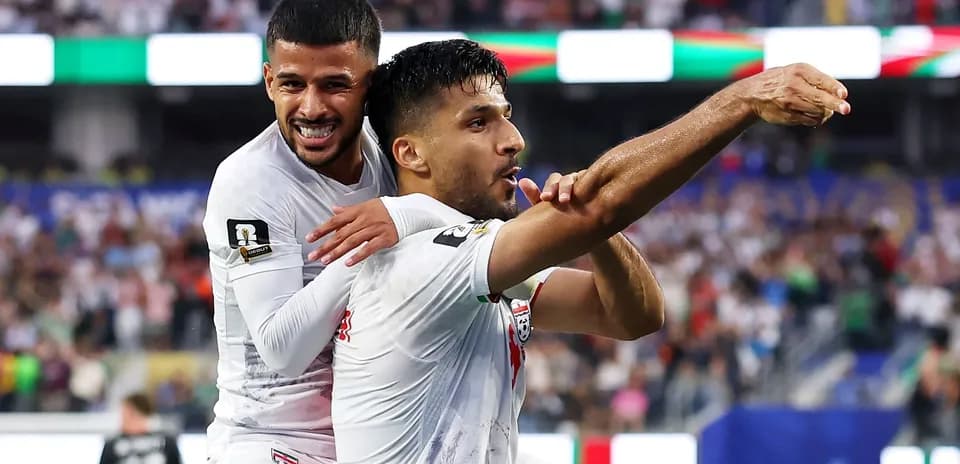 Two soccer players celebrating a goal together