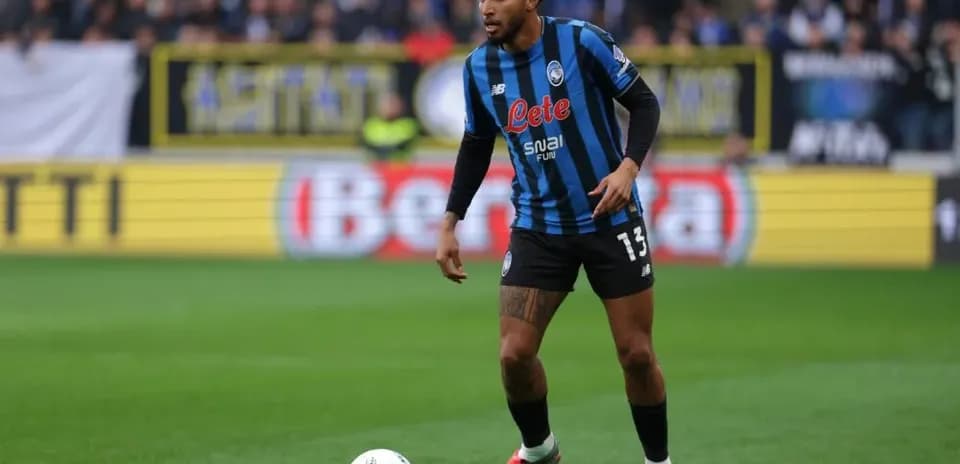 Player in Atalanta kit controlling the ball on field