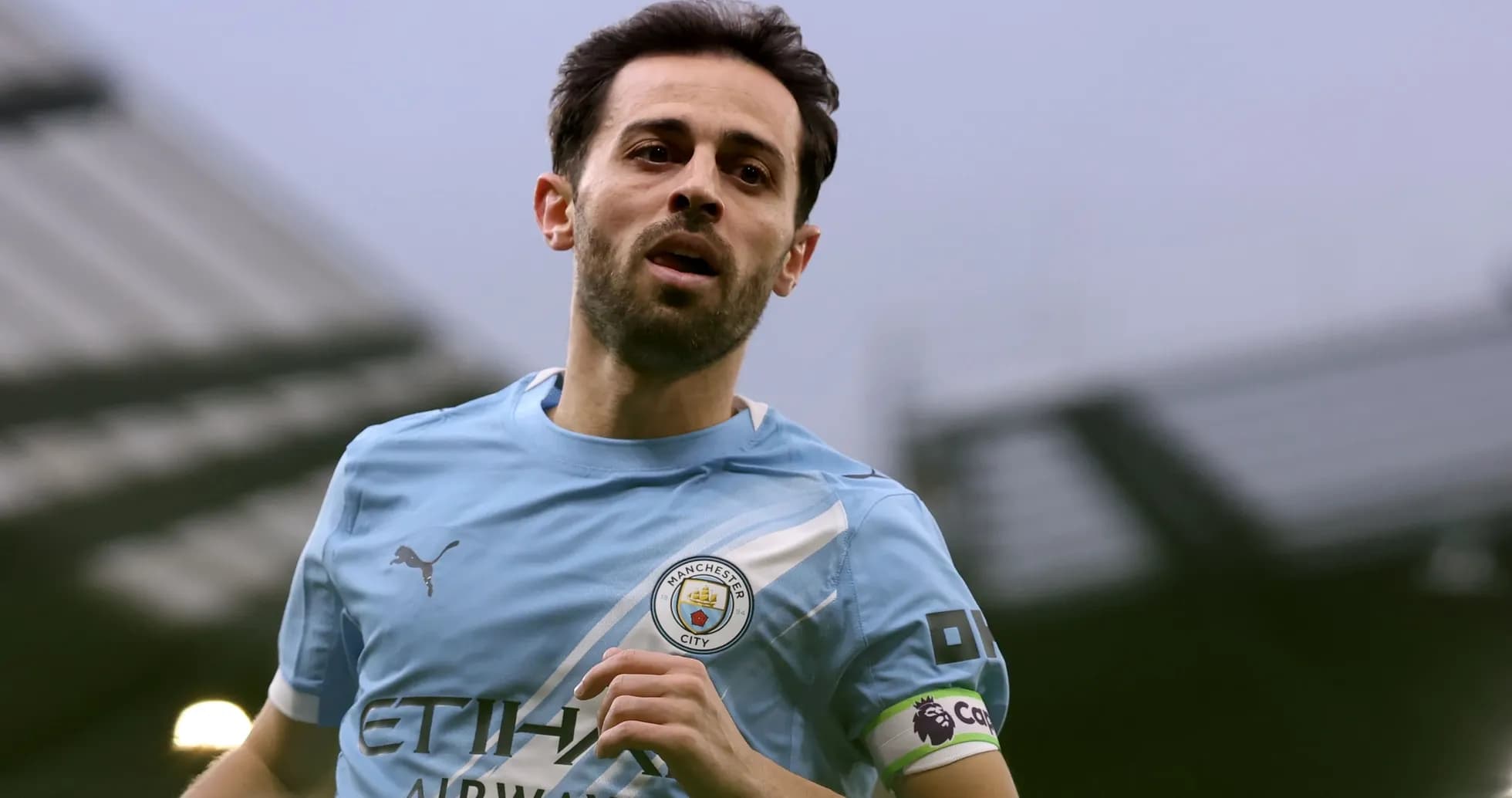 Player in Manchester City kit running on pitch