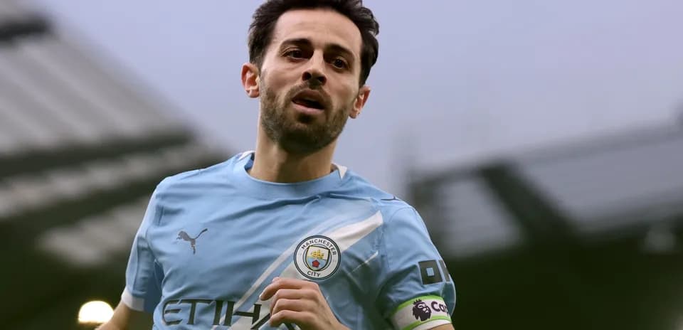 Player in Manchester City kit running on pitch