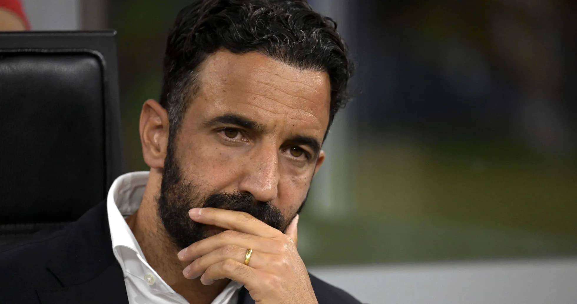 Coach thoughtfully observing the match from the bench