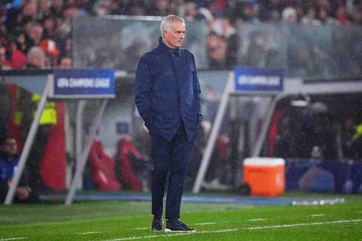 Coach standing on sideline during rainy match