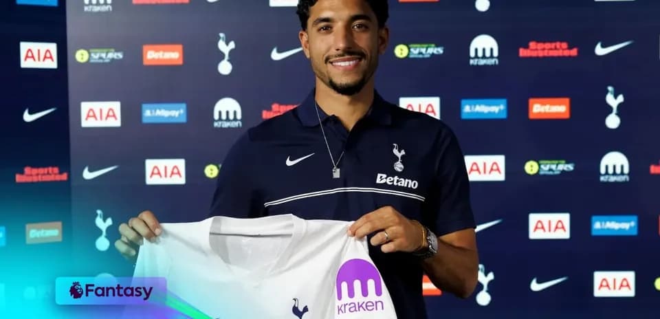 Player holding Tottenham jersey at press conference