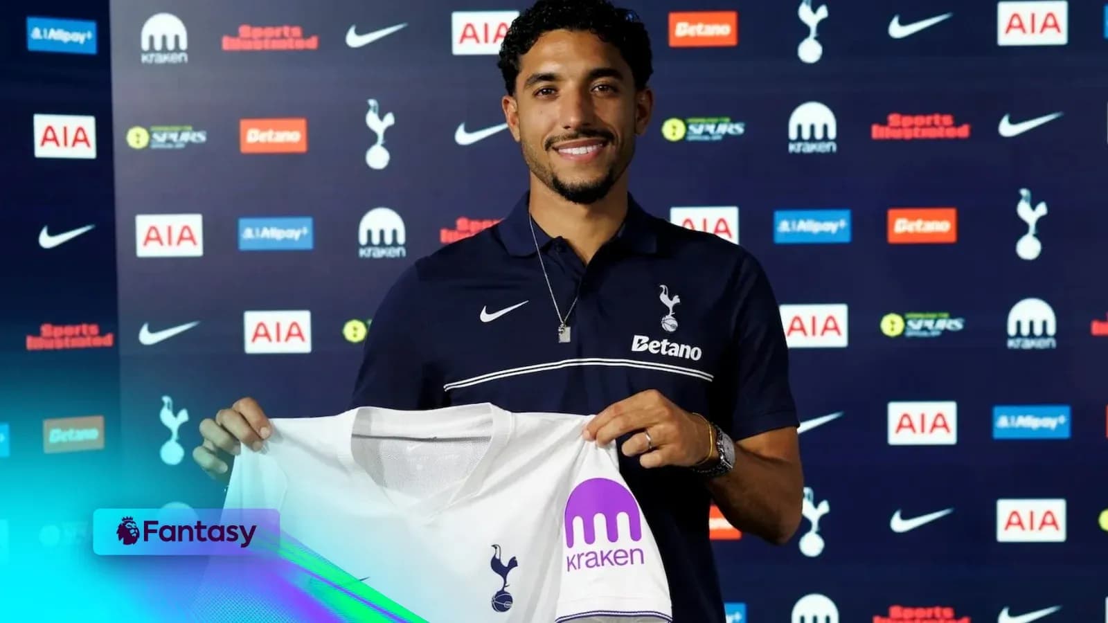 Player holding Tottenham jersey at press conference