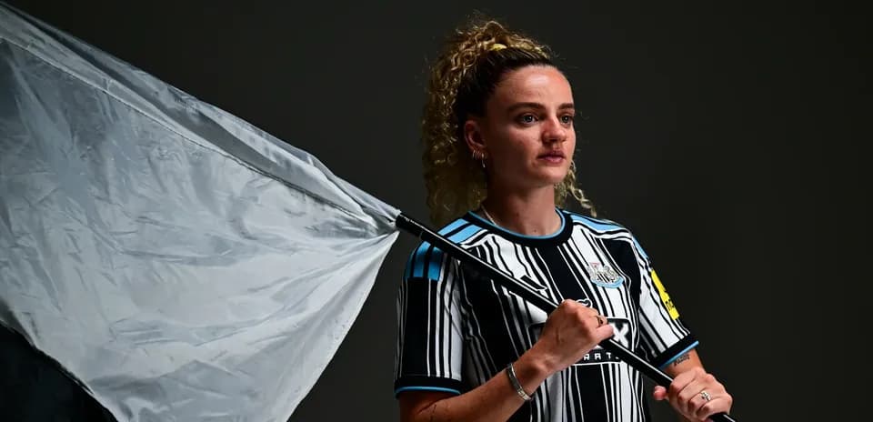 Player holding a flag in Newcastle jersey