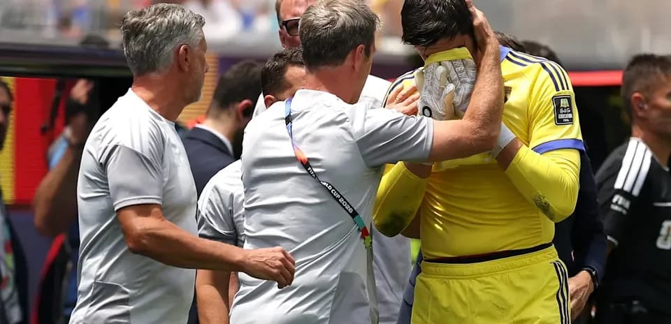 Coach comforting goalkeeper after match on sidelines