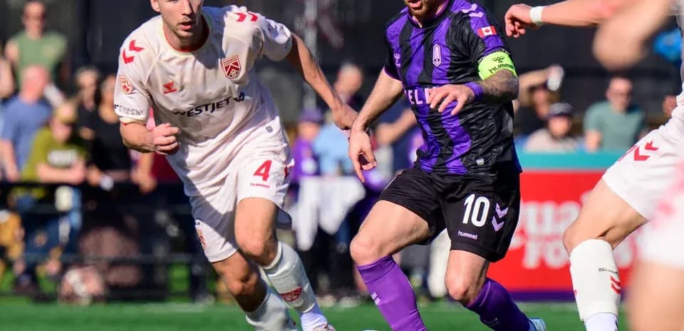 Cavalry FC player challenging Pacific FC opponent