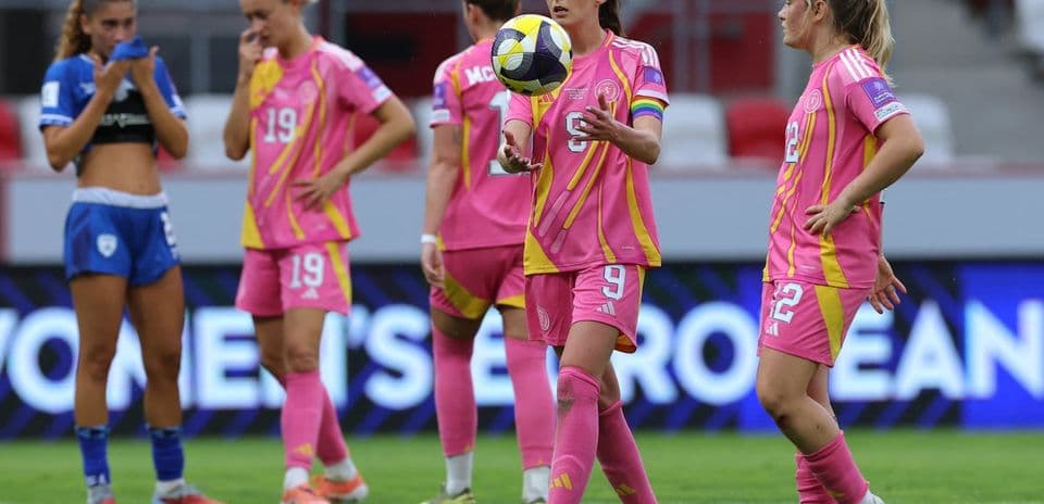 Players in pink jerseys on the field during match
