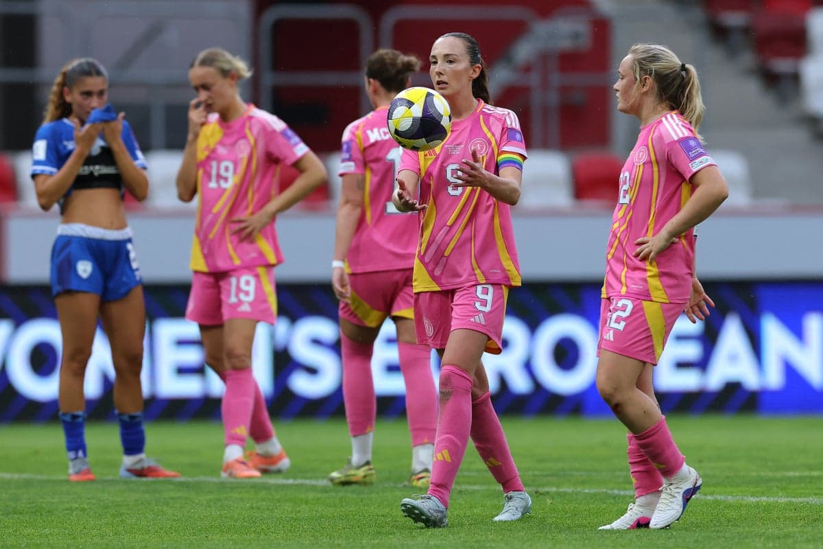 Players in pink jerseys on the field during match