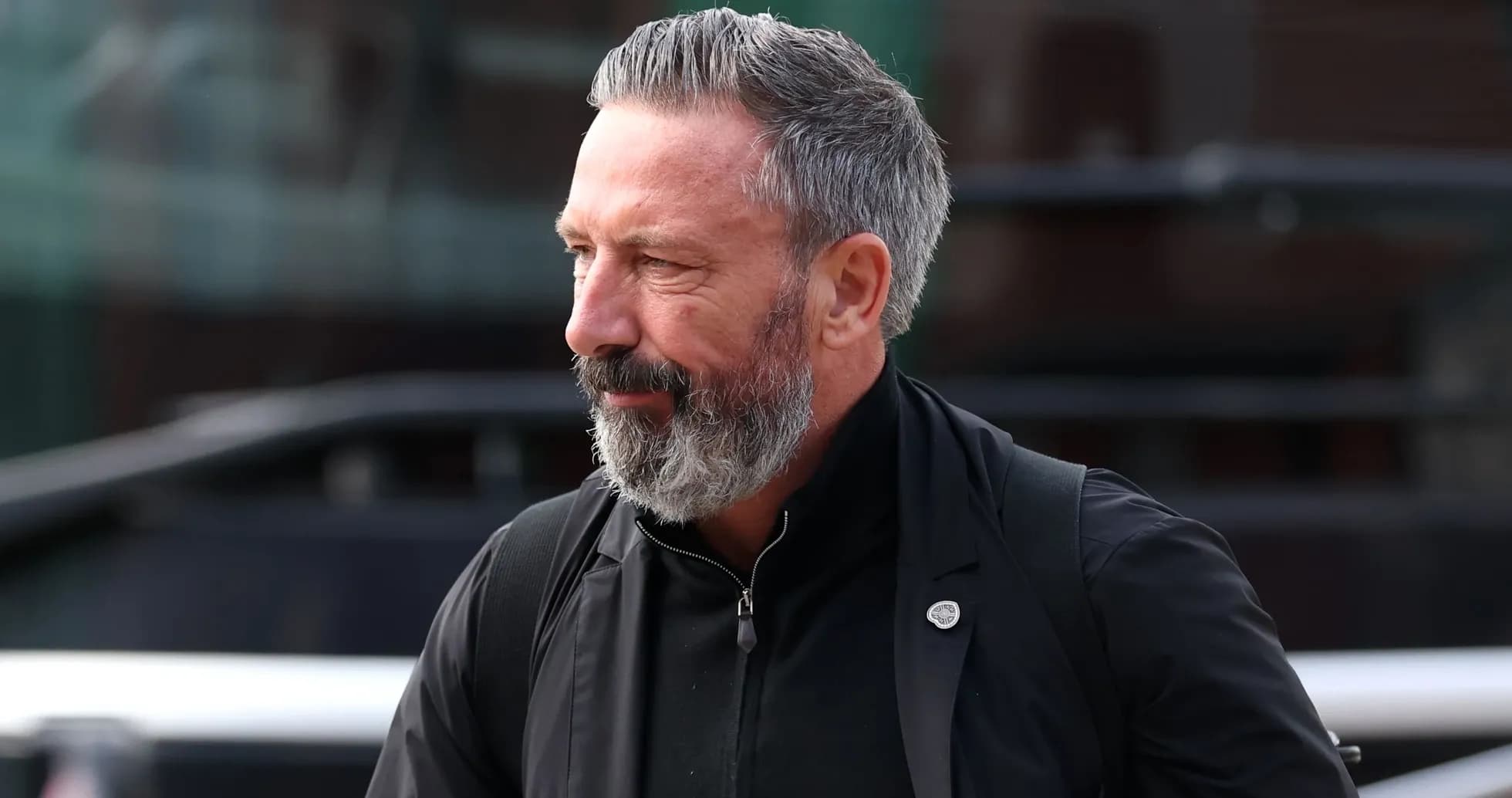 Man with gray beard walking outside venue