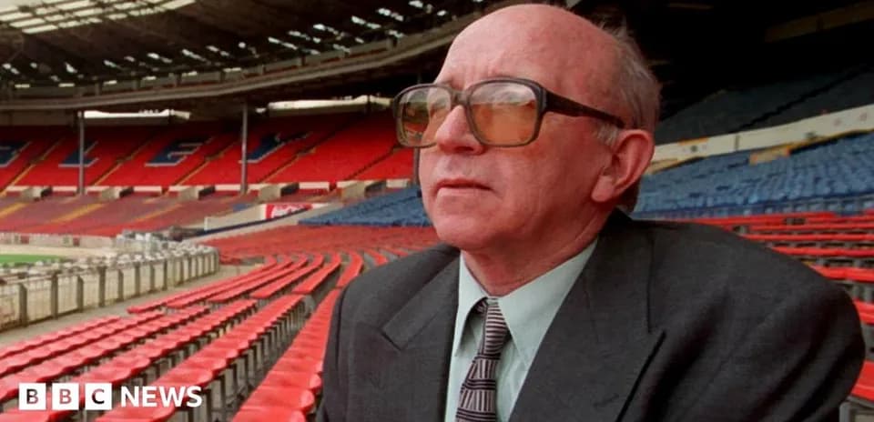 Person seated in empty stadium with red seats