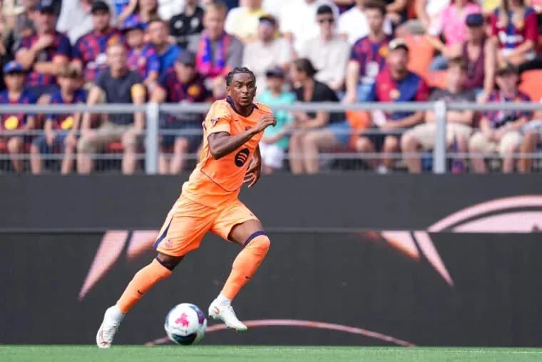 Player in orange kit sprinting on the pitch