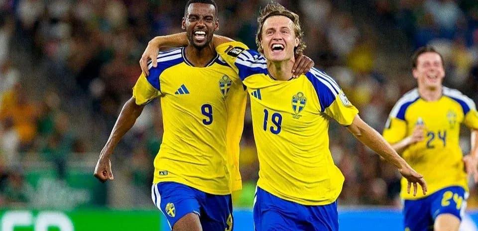 Two Swedish players celebrating a goal on the field