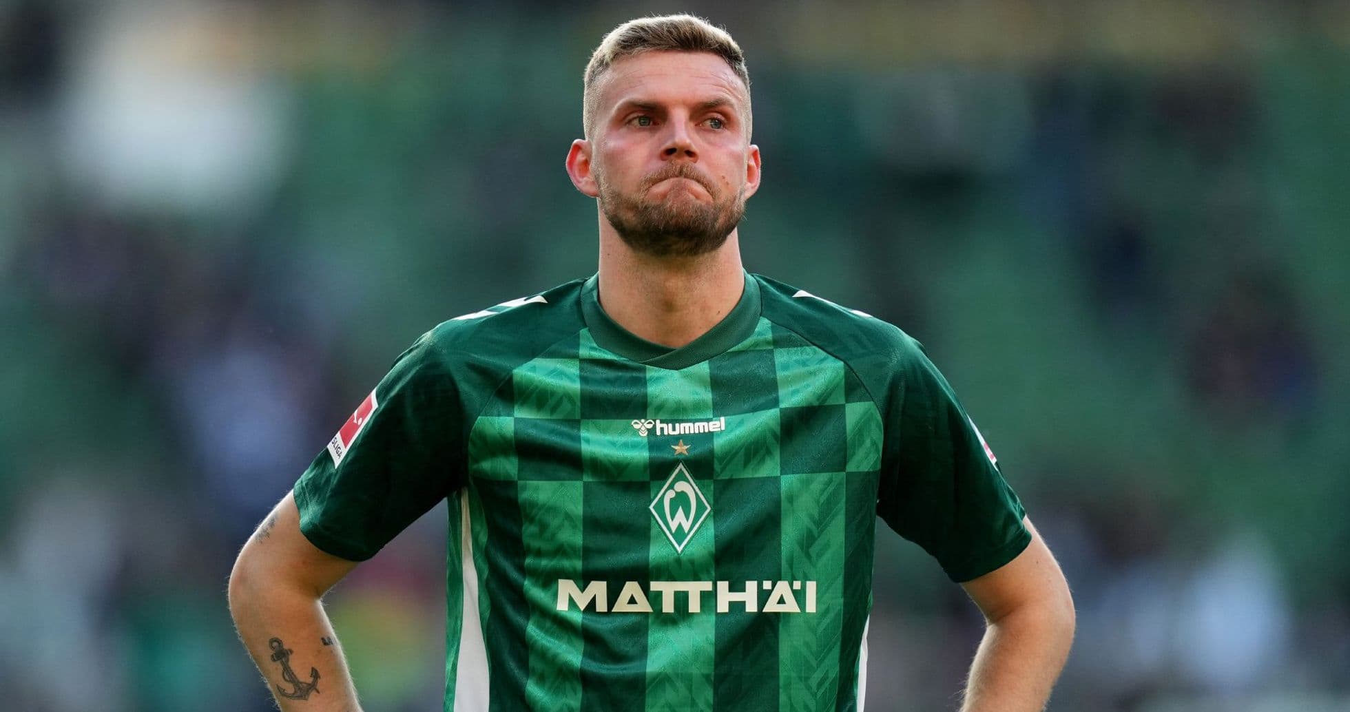 Player in green jersey standing on field