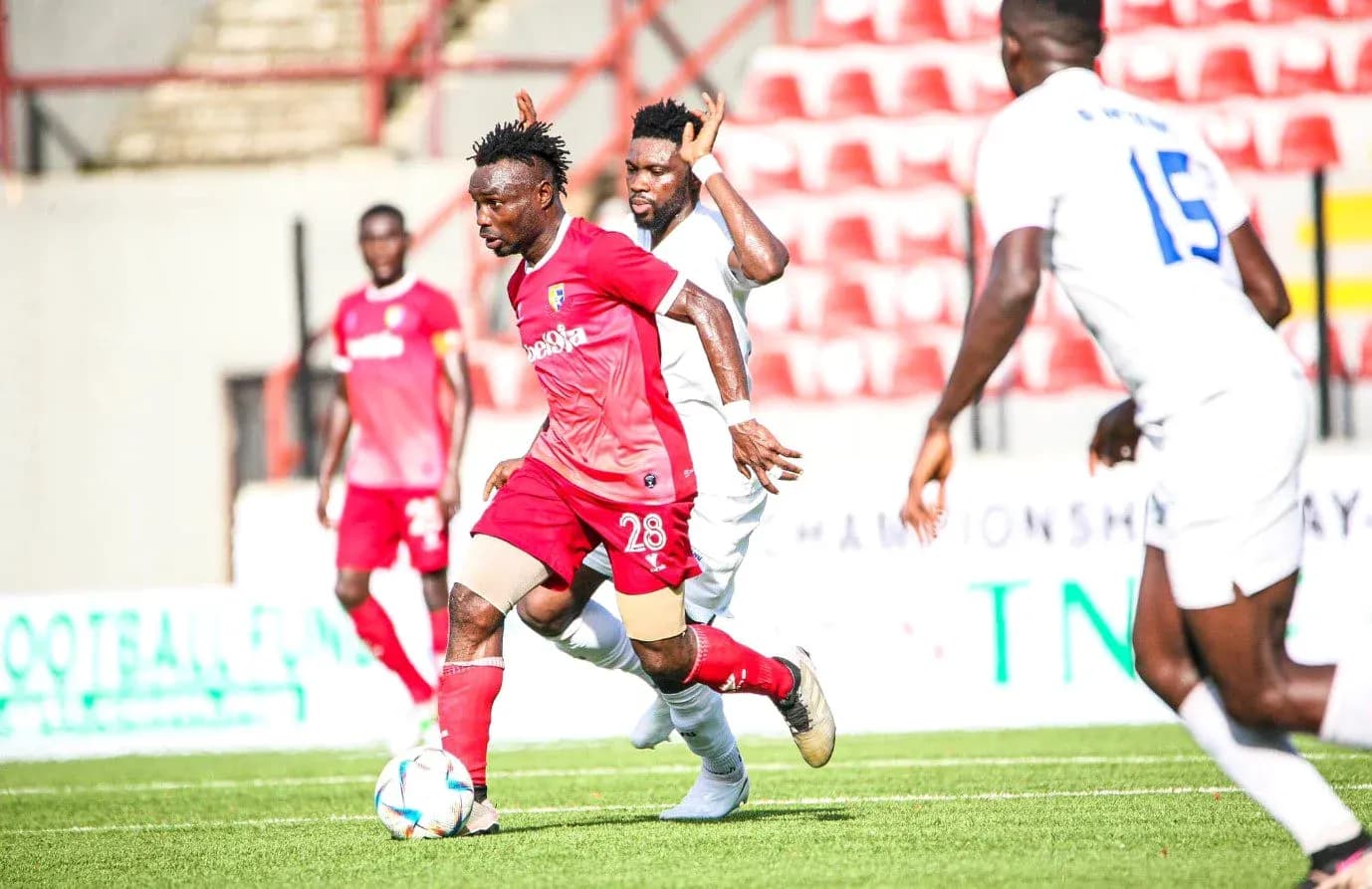 Katsina United player dribbling past Rivers United opponent