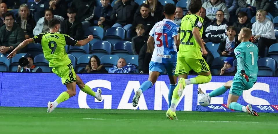 Player shooting at goal while goalkeeper prepares to save