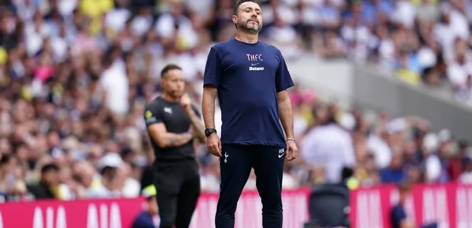 Manager on sidelines during football match