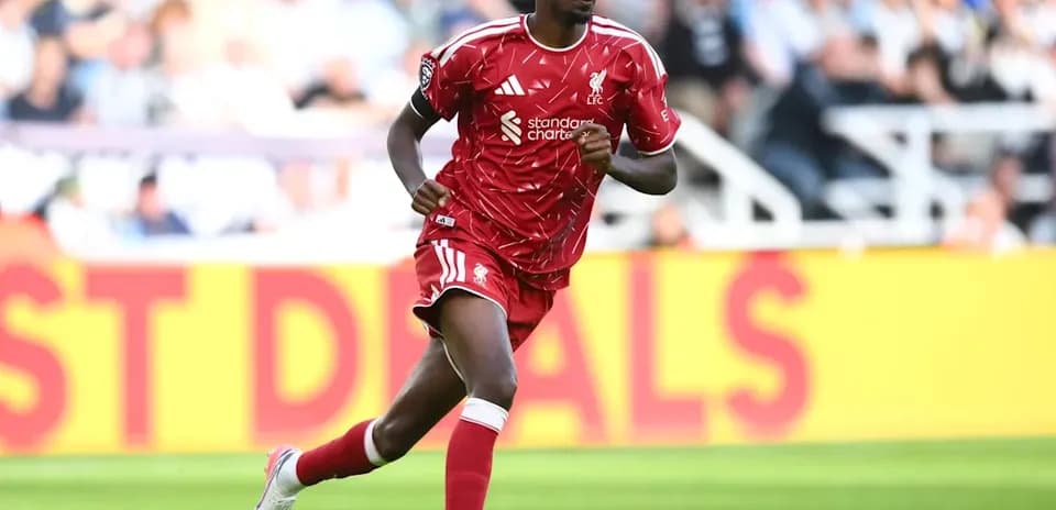 Player running on the pitch in red kit