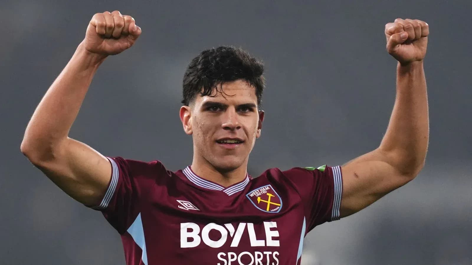 Player celebrating with raised fists in team jersey