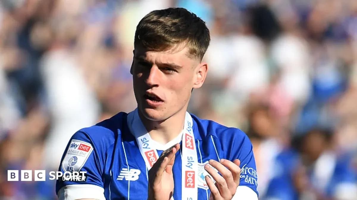 Player in blue jersey applauding fans after match Player in blue jersey applauding fans after match