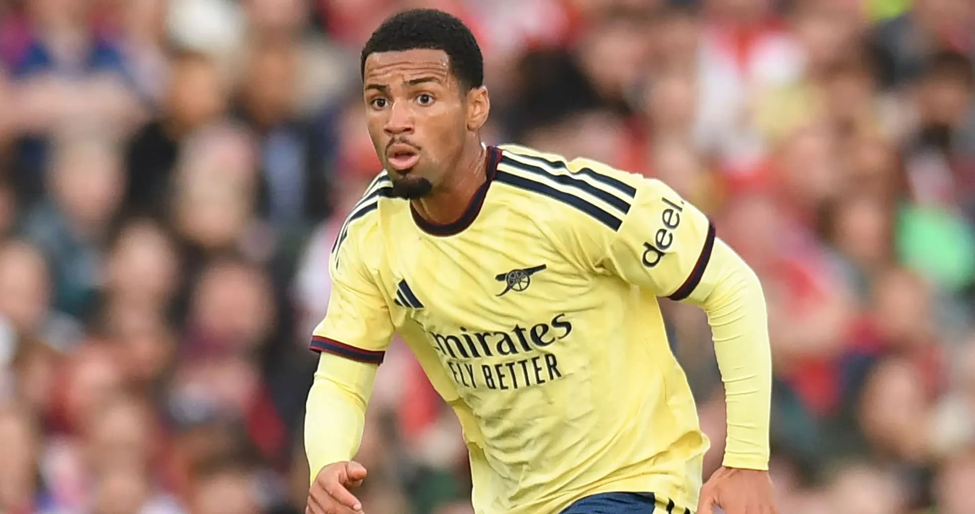 Player in Arsenal jersey running on the pitch Player in Arsenal jersey running on the pitch