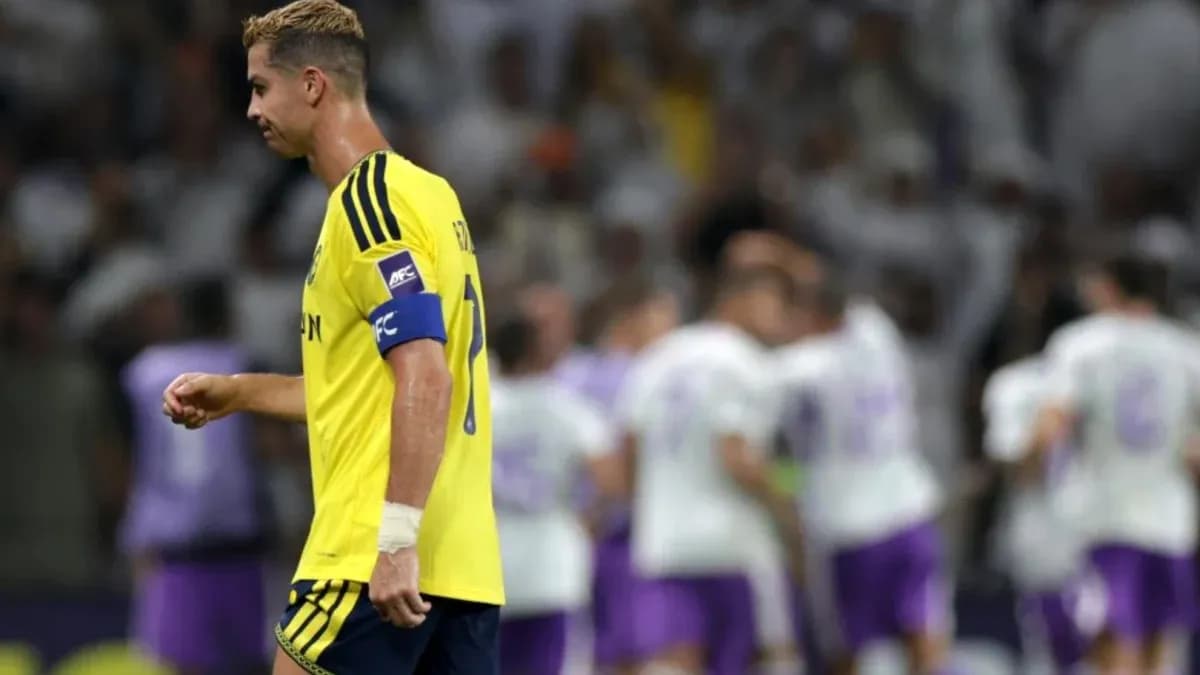 Player in yellow kit walking past celebrating teammates Player in yellow kit walking past celebrating teammates