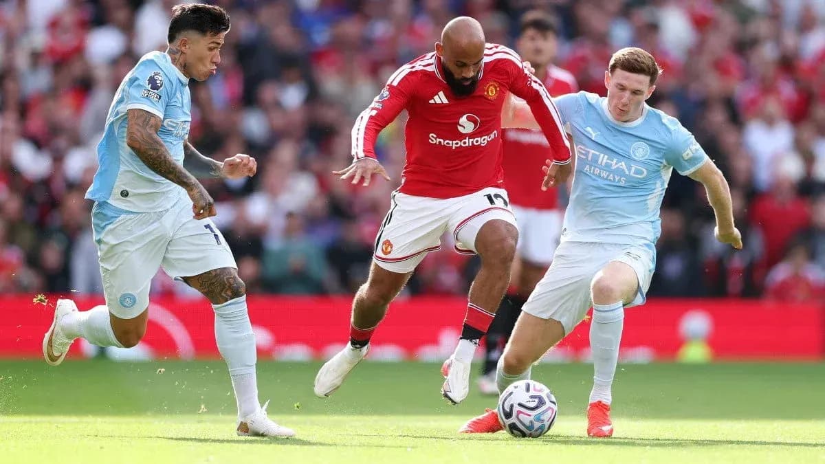 Players from Manchester United and Manchester City contesting for the ball Players from Manchester United and Manchester City contesting for the ball