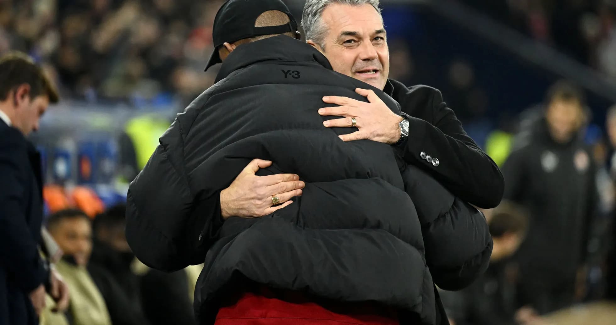 Two coaches embracing on the sidelines during match Two coaches embracing on the sidelines during match