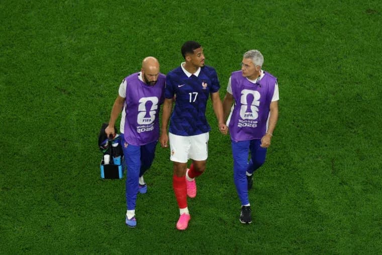 Player walking off field with medical staff assistance Player walking off field with medical staff assistance