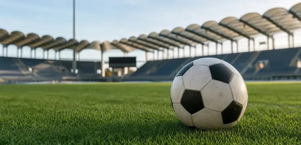 Soccer ball resting on grass in empty stadium Soccer ball resting on grass in empty stadium
