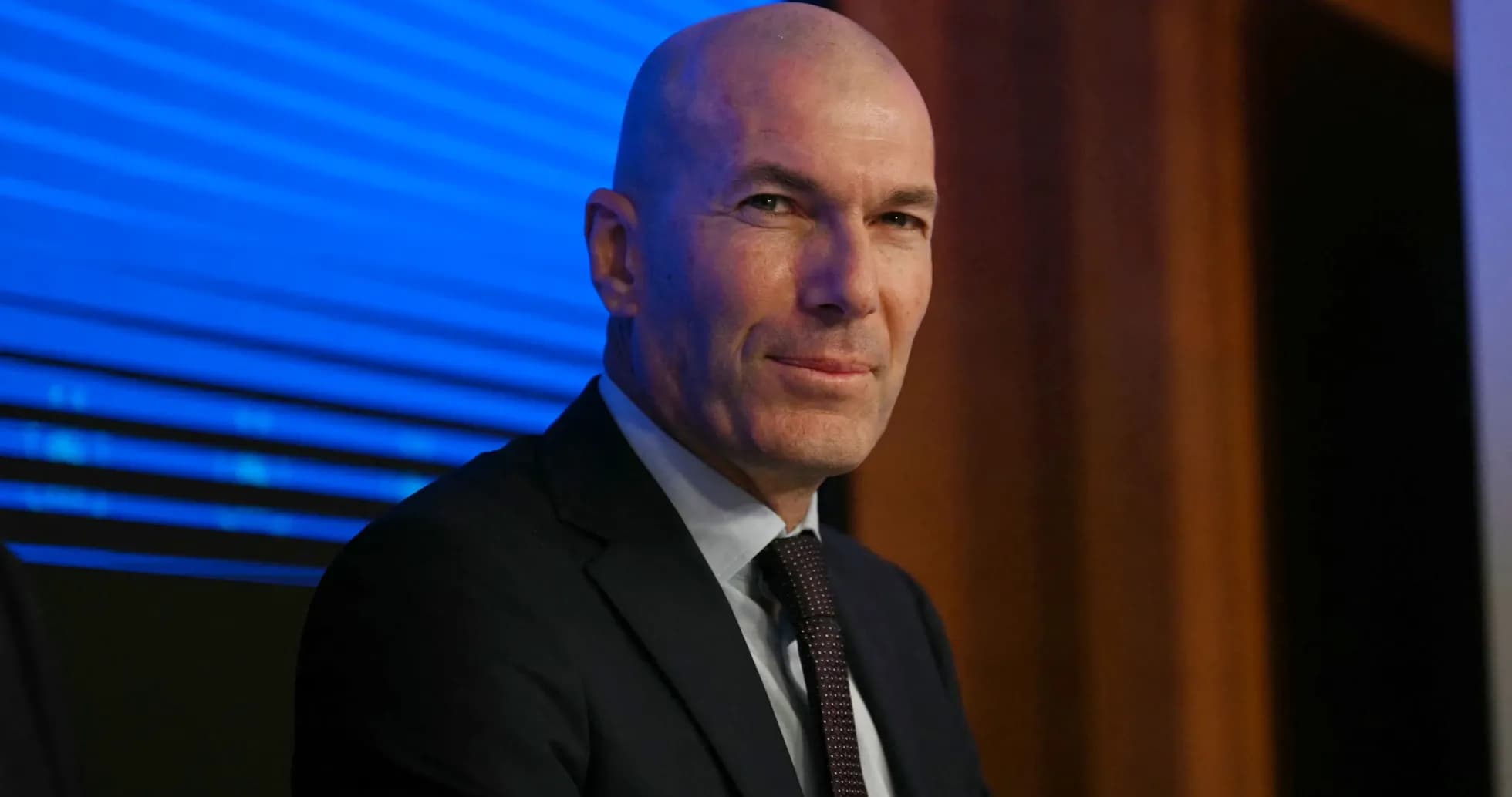 Man in suit sitting at a press conference Man in suit sitting at a press conference