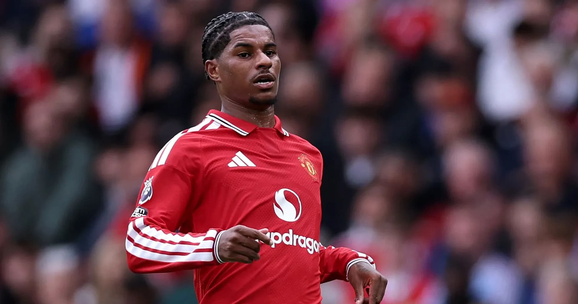 Player in red Manchester United jersey on pitch Player in red Manchester United jersey on pitch