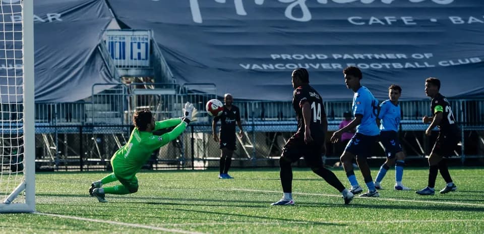 Goalkeeper diving to save a shot on goal Goalkeeper diving to save a shot on goal
