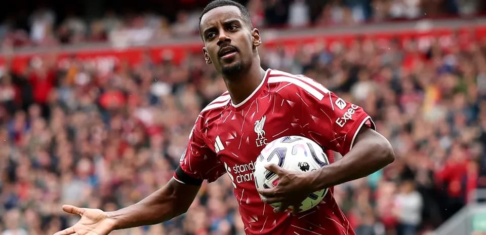Player in Liverpool jersey holding a football Player in Liverpool jersey holding a football