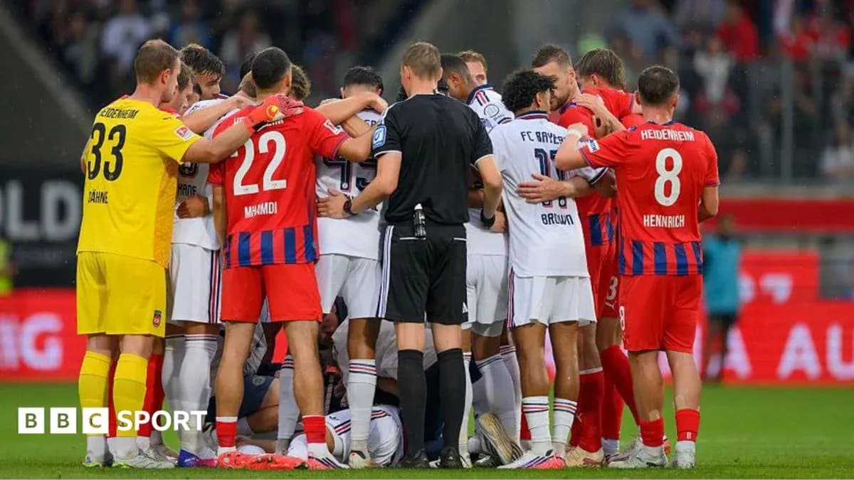 Players from both teams gathered around injured player Players from both teams gathered around injured player